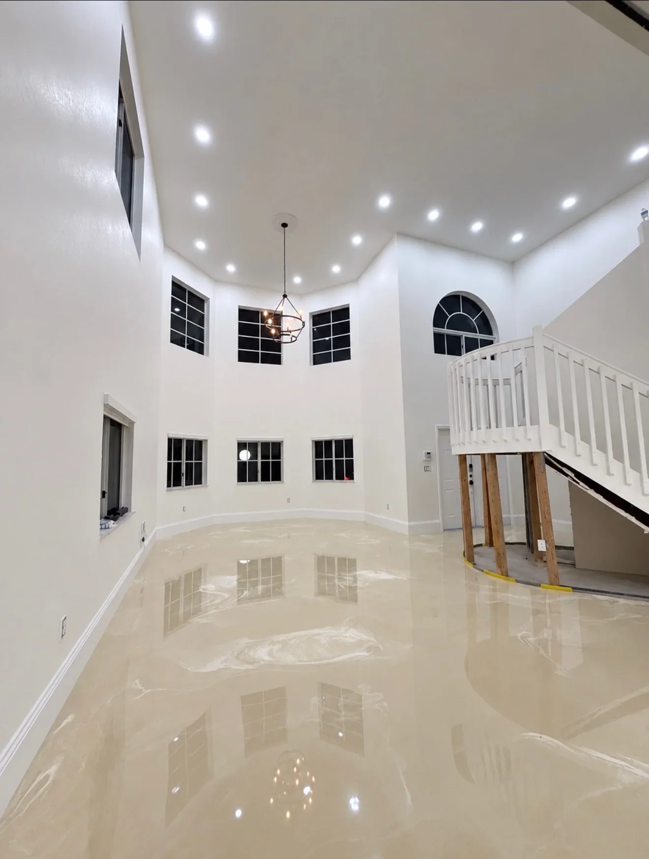 Polished epoxy flooring with marble effect in two-story residential space with white walls and recessed lighting