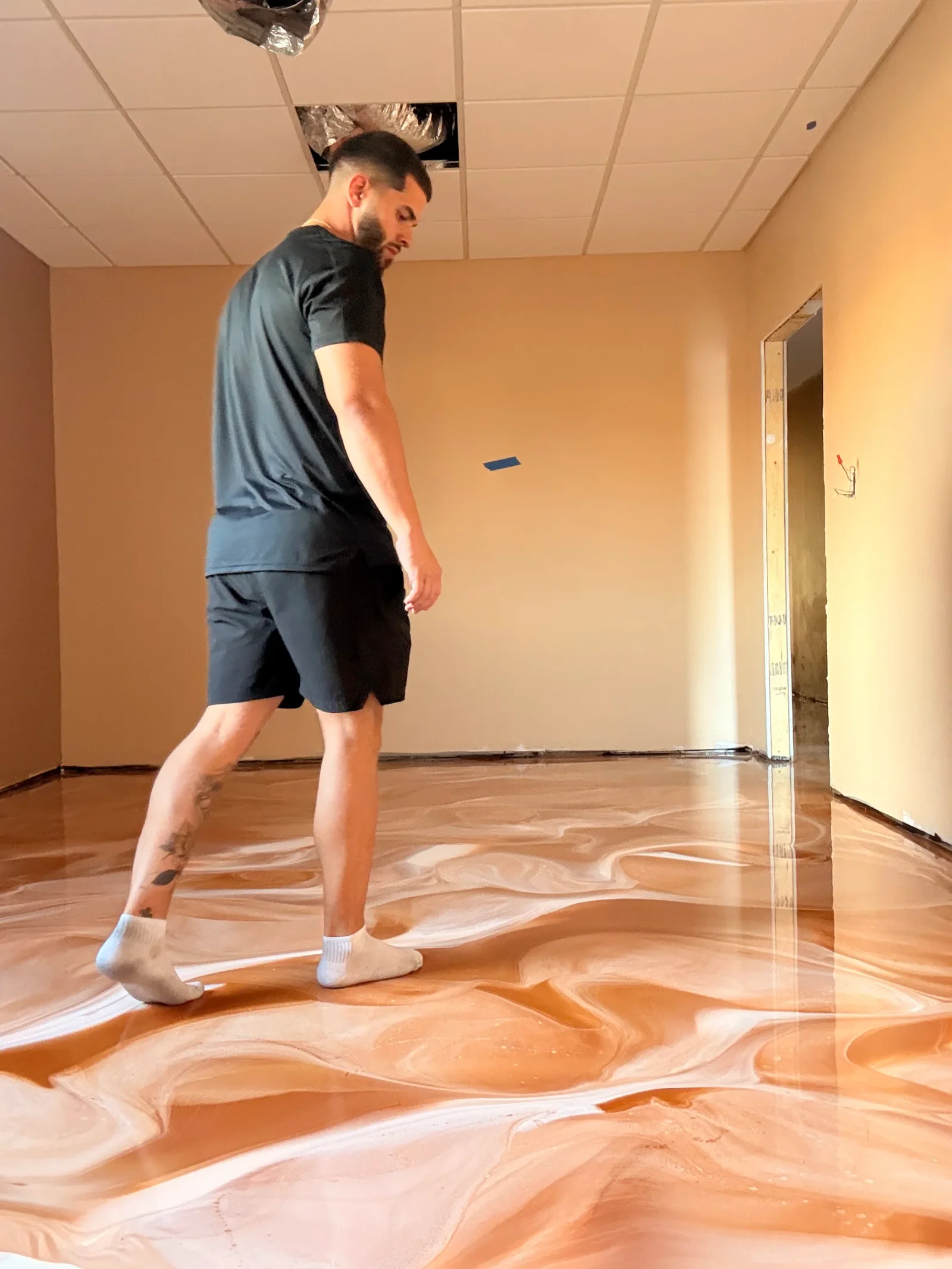 Glossy epoxy resin floor with amber and white swirl pattern in commercial space
