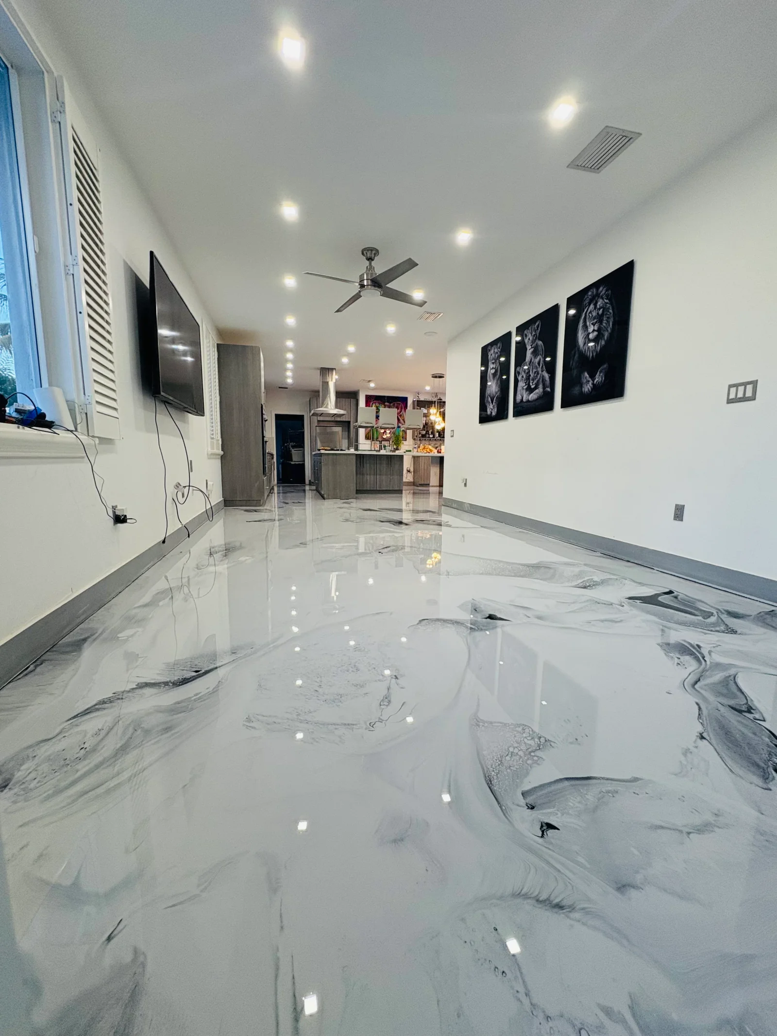 White and gray marble-effect epoxy floor with swirled veining in commercial space with LED lighting