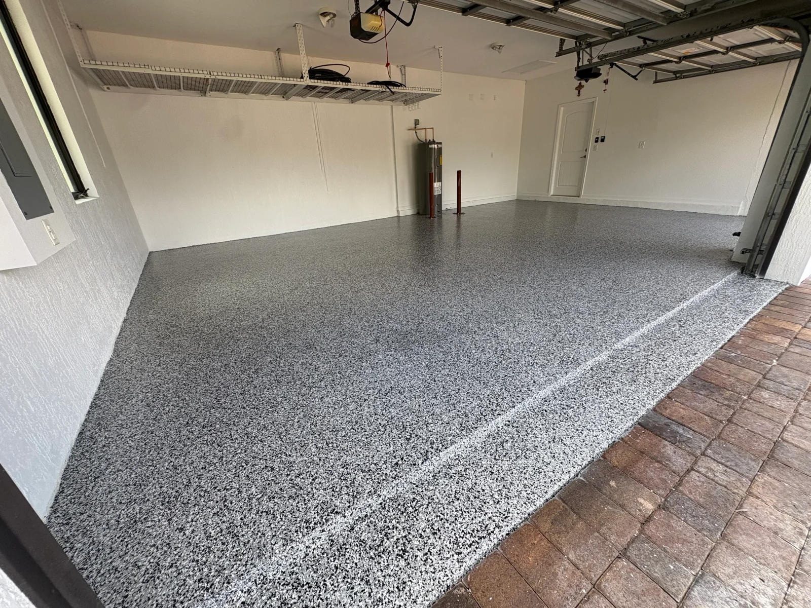 Speckled gray epoxy garage floor with white border stripe and white walls