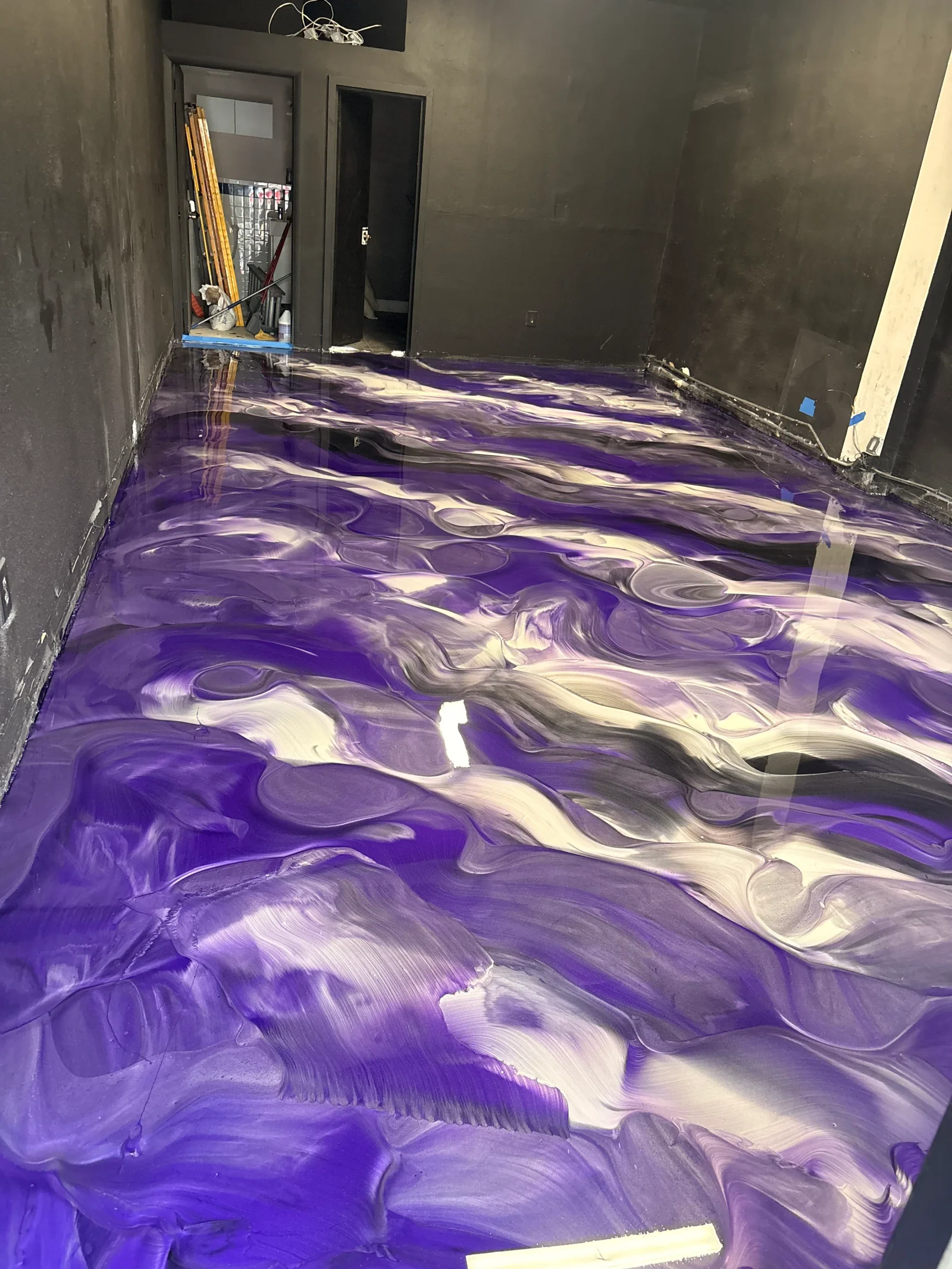 Purple and white metallic epoxy resin floor with swirled patterns and high-gloss finish