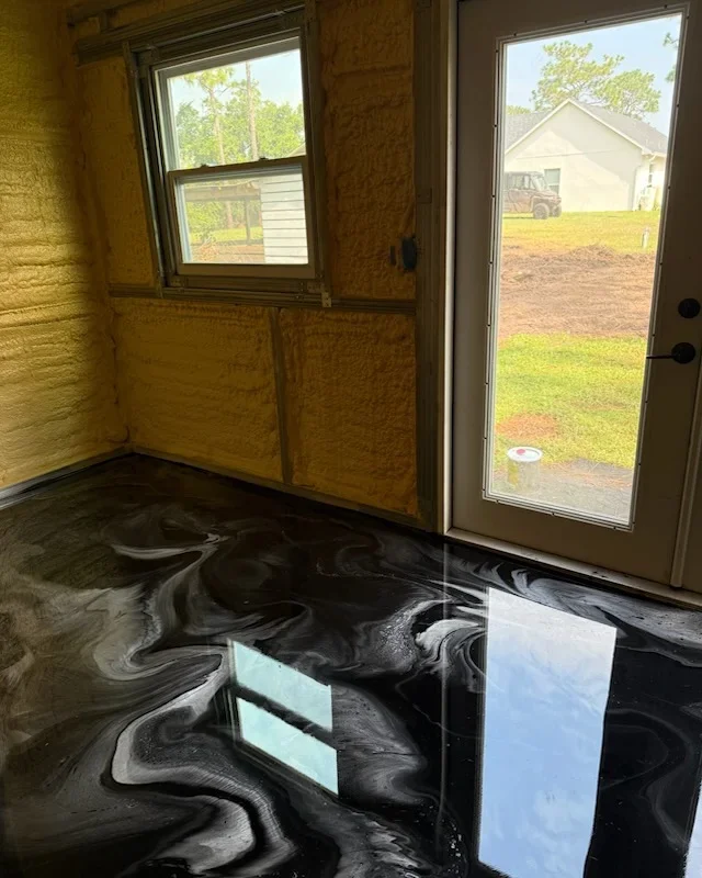 Black and silver metallic epoxy floor with swirled pattern, high-gloss finish in residential space