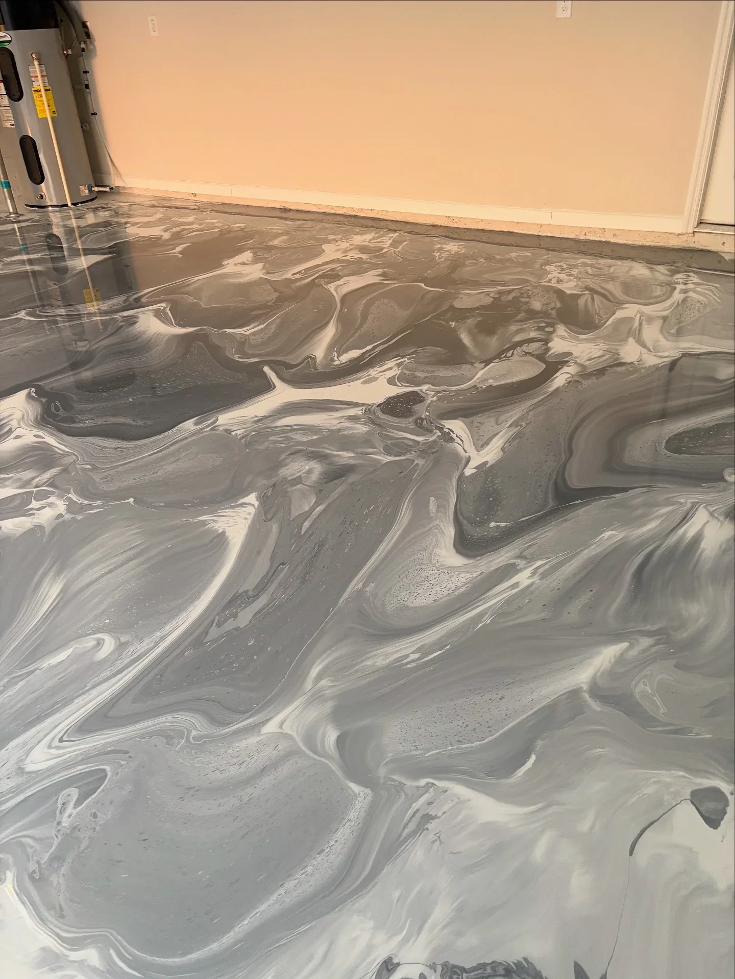 Metallic epoxy floor with gray and white swirled patterns and high-gloss finish