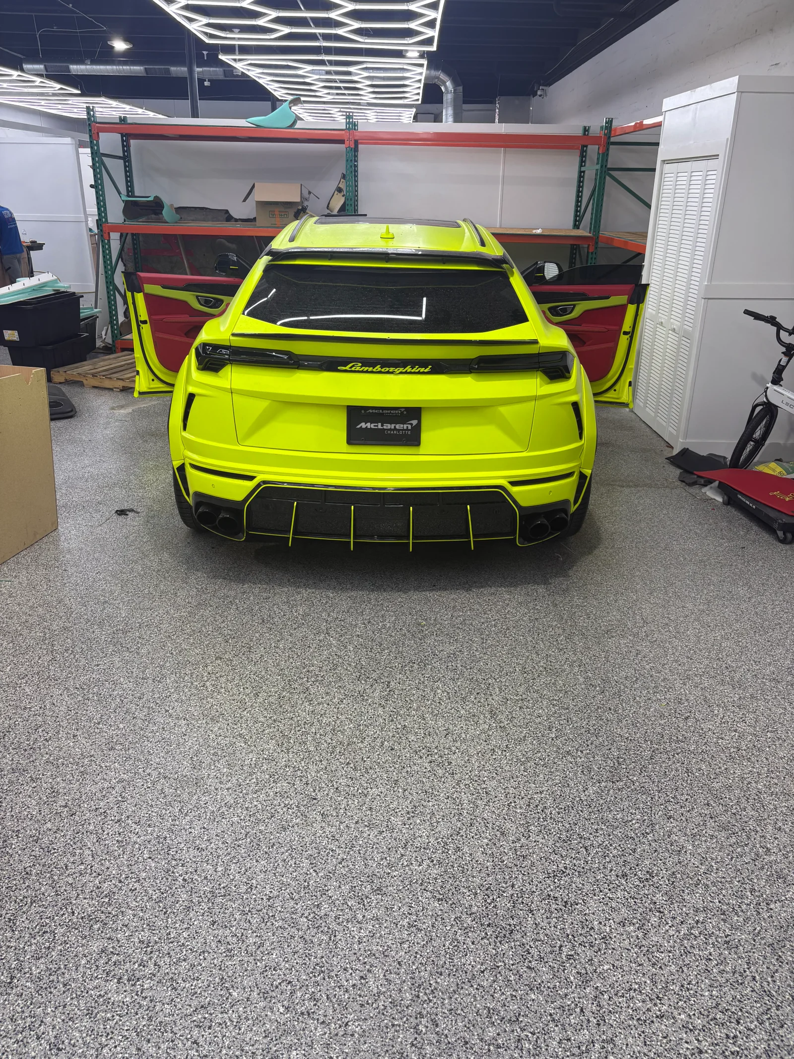 Gray epoxy garage floor with yellow sports car and metal shelving