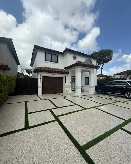 Permeable concrete pavers with grass strips in geometric grid pattern on residential driveway