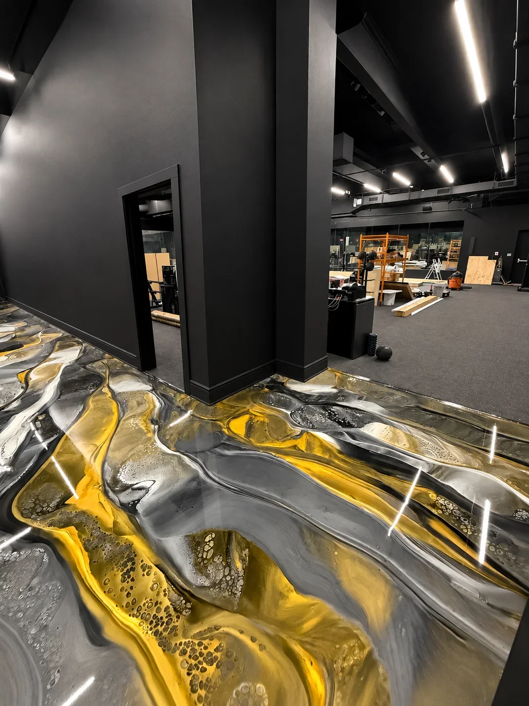 Metallic epoxy floor with yellow and silver swirled patterns, high-gloss finish in commercial space